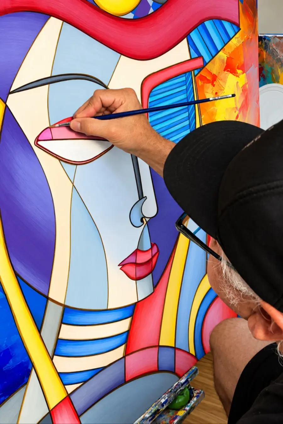 An artist painting a colorful abstract portrait