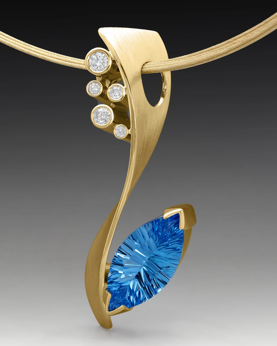 Sculptural gold pendant with diamonds and a blue gemstone by Dorothee Naumburg