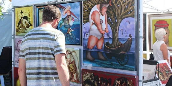 Visitors browsing paintings at an outdoor art festival — Vermillion Promotions gallery