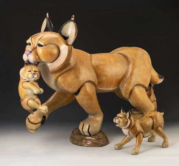 Bronze wildcat mother carrying a kitten, with another kitten beside her, by Jason Napier